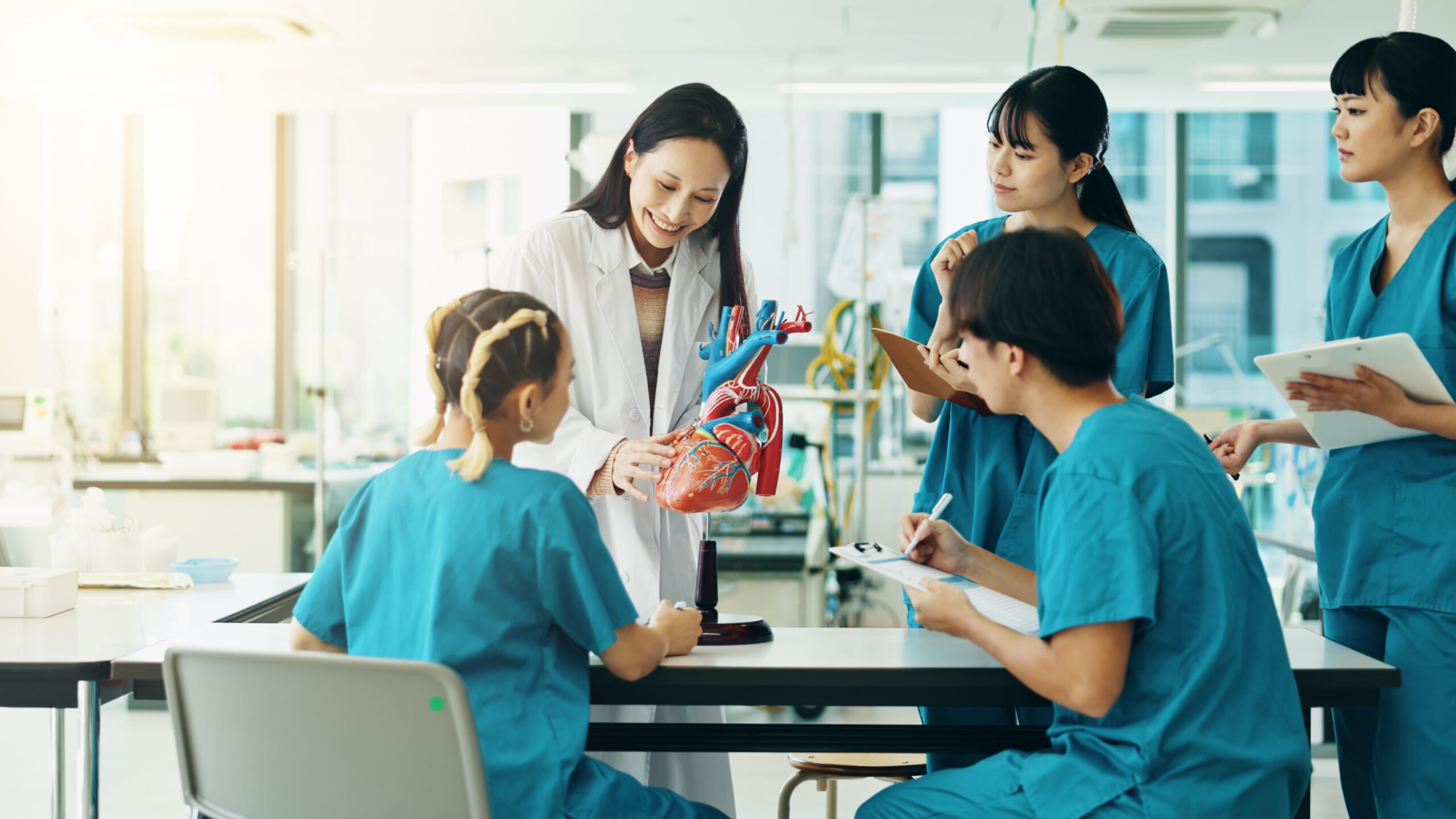 A professor training students in a hospital setting